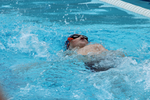 MB Dolphin Swim Team member swimming backstroke in the November 12, 2017 swim meet