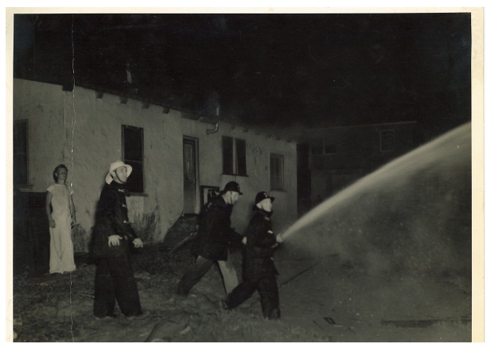 Firefighters using hose with girl